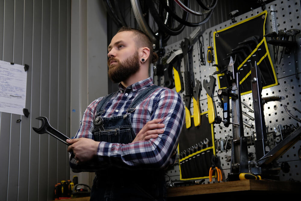 כלי עבודה למוסכים מאמר portrait-handsome-stylish-male-with-beard-haircut-wearing-flannel-shirt-jeans-coverall-holds-steel-wrench-standing-workshop-against-wall-tools (1) (1)